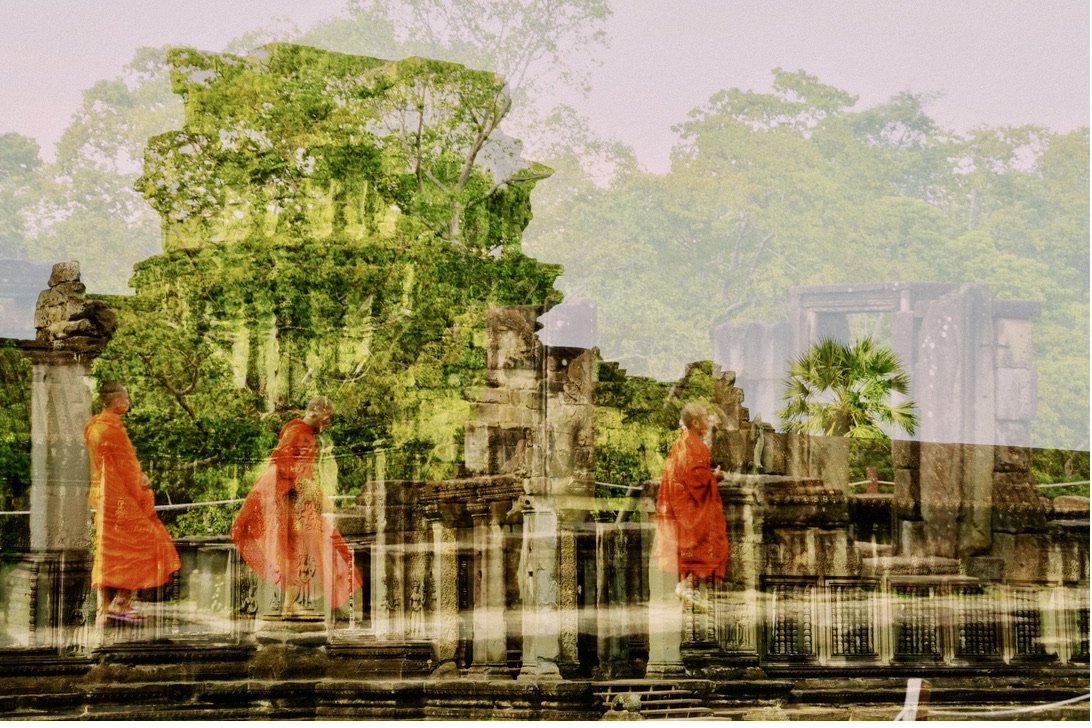 Moines en orange traversant les ruines du Baphuon